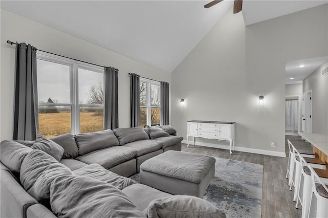 living room featuring high vaulted ceiling, wood finished floors, visible vents, and baseboards