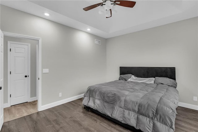 bedroom featuring baseboards, wood finished floors, and recessed lighting