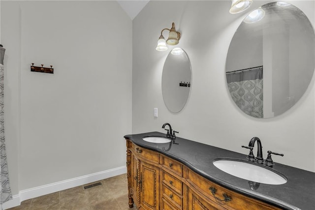 full bathroom with double vanity, a sink, visible vents, and baseboards