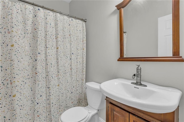 bathroom featuring toilet, a shower with shower curtain, and vanity