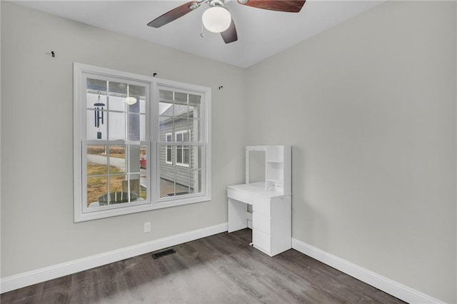 unfurnished bedroom featuring a ceiling fan, baseboards, visible vents, and wood finished floors