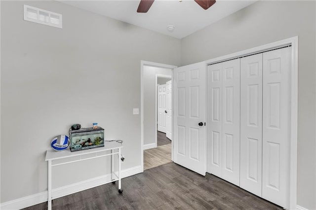 bedroom featuring a closet, visible vents, a ceiling fan, wood finished floors, and baseboards