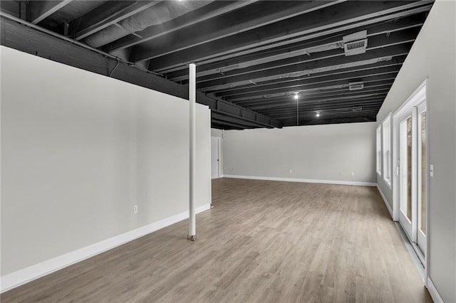 basement featuring wood finished floors and baseboards