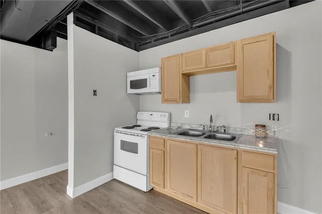 kitchen featuring a sink, white appliances, light wood-type flooring, and light brown cabinets