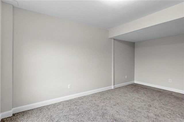 spare room featuring carpet floors and baseboards