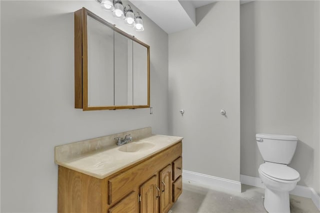 bathroom with vanity, toilet, and baseboards