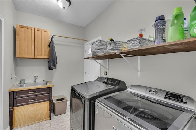 laundry area with light floors, cabinet space, independent washer and dryer, and a sink