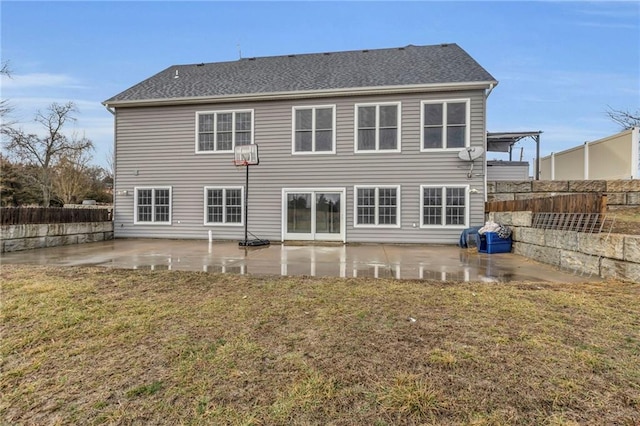 rear view of property featuring a lawn, a patio area, and fence