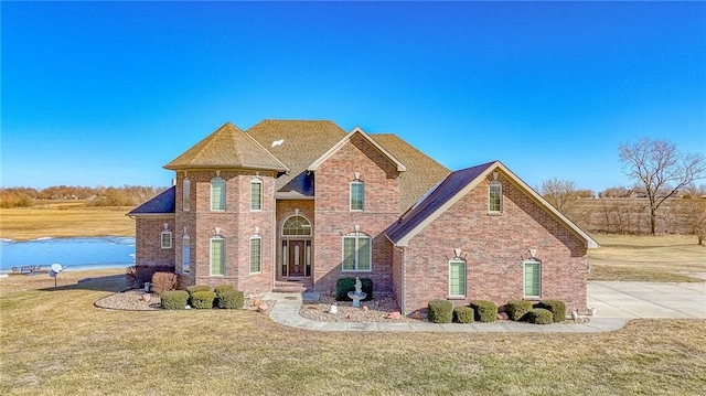 traditional-style house featuring a front yard and brick siding