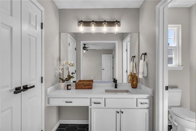 bathroom featuring tile patterned flooring, vanity, toilet, and a ceiling fan