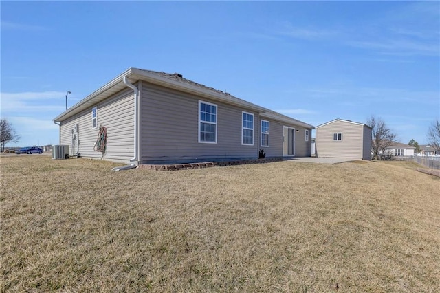 back of house with a lawn and central AC unit