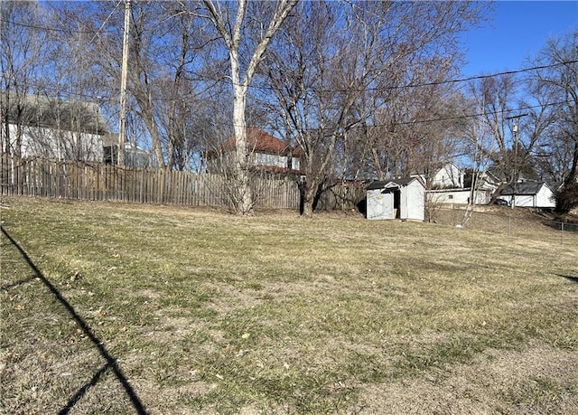 view of yard with an outbuilding, fence, and a storage unit