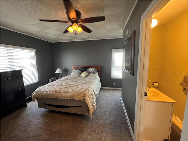 carpeted bedroom featuring ornamental molding, a ceiling fan, and baseboards