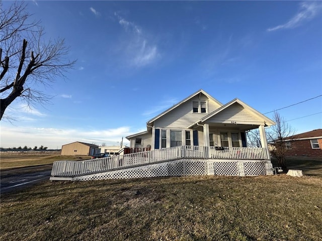 rear view of house featuring a porch and a lawn