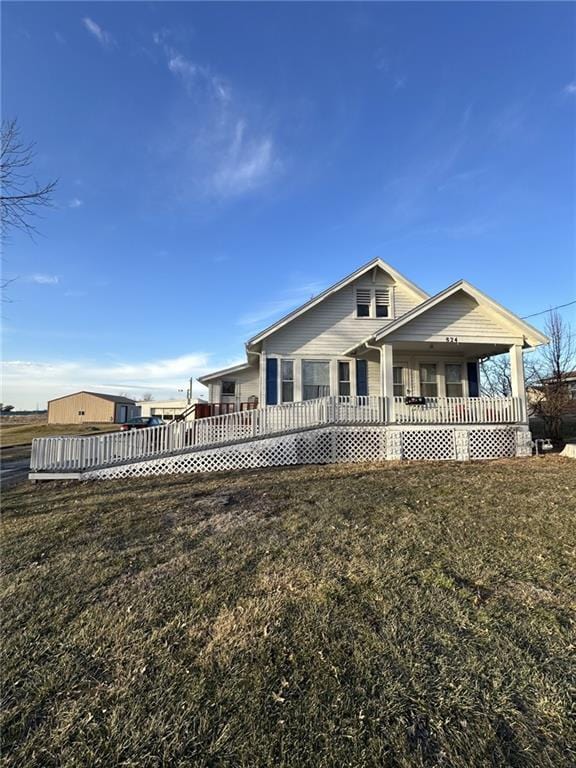 back of property with covered porch and a yard