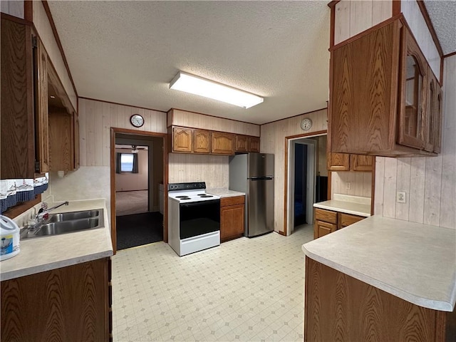 kitchen featuring electric stove, light floors, a sink, and freestanding refrigerator