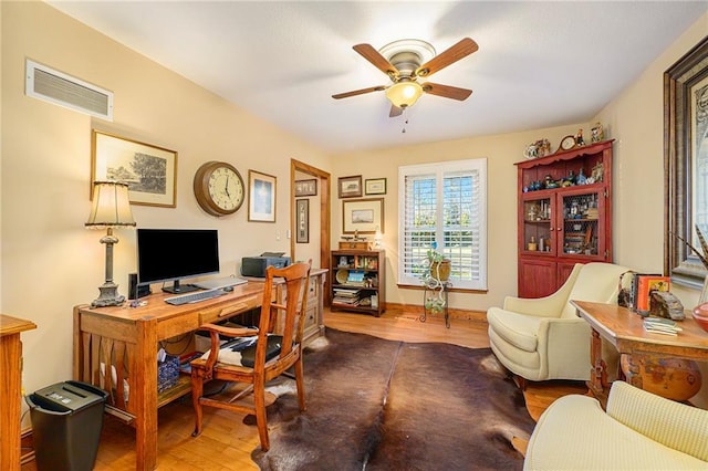 office space with visible vents, baseboards, wood finished floors, and a ceiling fan