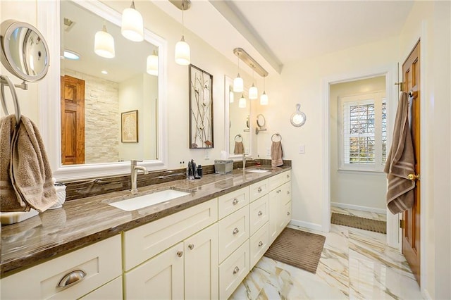 bathroom with a sink, baseboards, marble finish floor, and double vanity