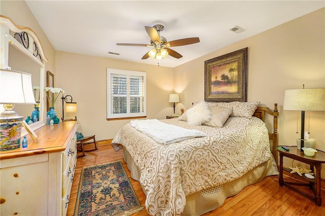 bedroom with visible vents, ceiling fan, and wood finished floors