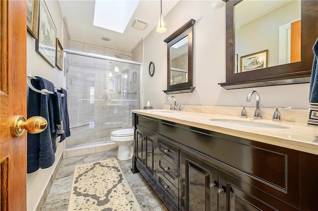 bathroom featuring visible vents, toilet, a skylight, and a sink