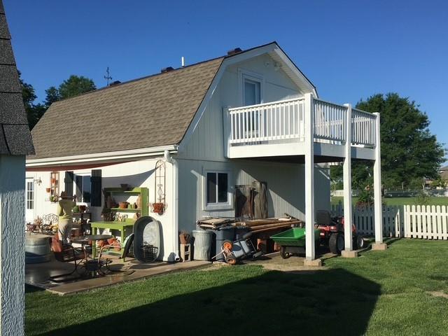 back of property featuring a gambrel roof, a patio, fence, a yard, and a shingled roof