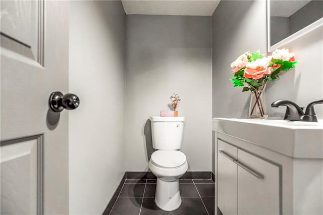 half bathroom with toilet, vanity, and tile patterned floors