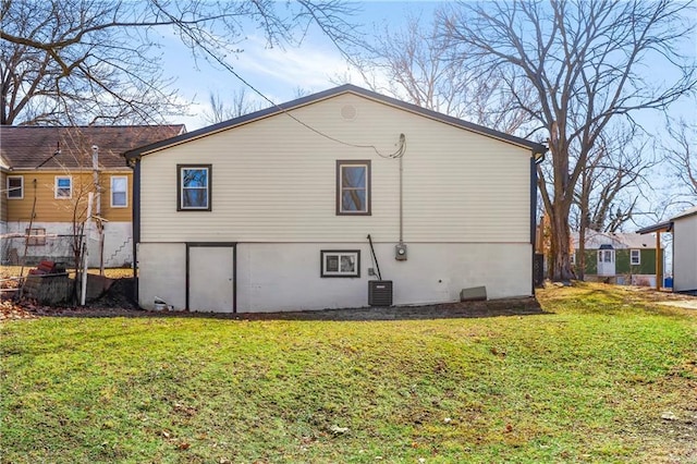 back of property with central AC and a yard