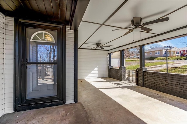 doorway to property with driveway, covered porch, a residential view, and a ceiling fan