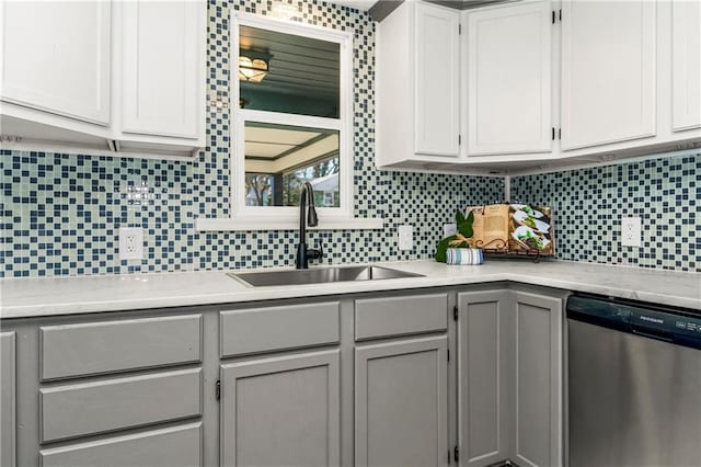 kitchen with dishwasher, a sink, white cabinetry, and decorative backsplash