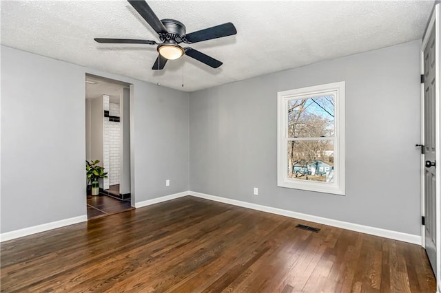 unfurnished room featuring dark wood-style floors, visible vents, ceiling fan, a textured ceiling, and baseboards