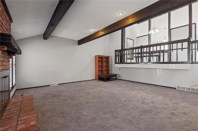 unfurnished living room with lofted ceiling with beams, a textured ceiling, carpet flooring, and visible vents