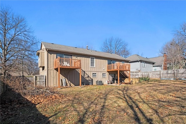 rear view of house with a fenced backyard, stairs, a lawn, and a wooden deck