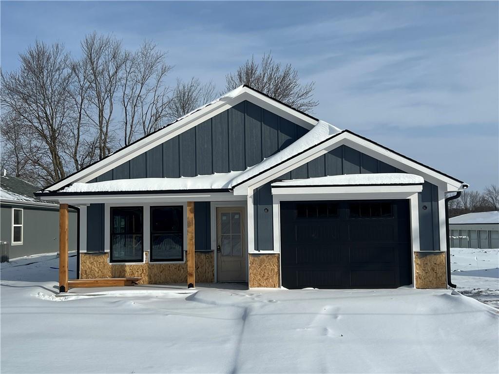 view of front of property featuring a garage, stone siding, a porch, and board and batten siding