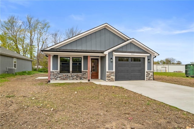 607 W Dryden St, Odessa, MO 64076 - craftsman-style home with an attached garage, stone siding, covered porch, and driveway