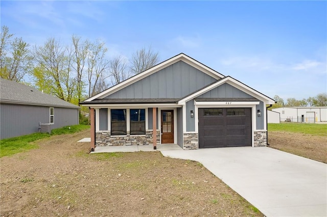 607 W Dryden St, Odessa, MO 64076 - craftsman-style house with a porch, a garage, stone siding, and driveway