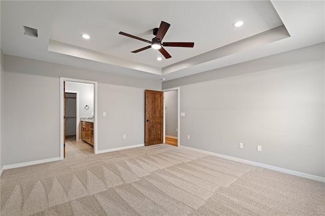 607 W Dryden St, Odessa, MO 64076 - unfurnished bedroom featuring baseboards, recessed lighting, visible vents, a tray ceiling, and light colored carpet
