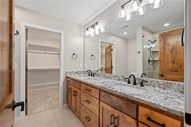 607 W Dryden St, Odessa, MO 64076 - bathroom featuring a spacious closet, double vanity, a sink, and a stall shower