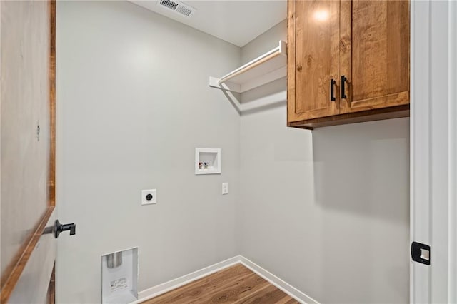 607 W Dryden St, Odessa, MO 64076 - clothes washing area with visible vents, hookup for an electric dryer, wood finished floors, cabinet space, and hookup for a washing machine