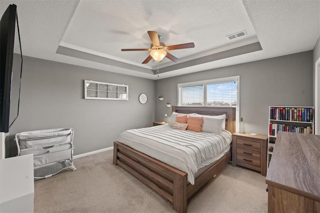 bedroom featuring a raised ceiling, light colored carpet, and visible vents