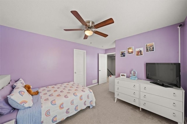 bedroom with a ceiling fan and light colored carpet