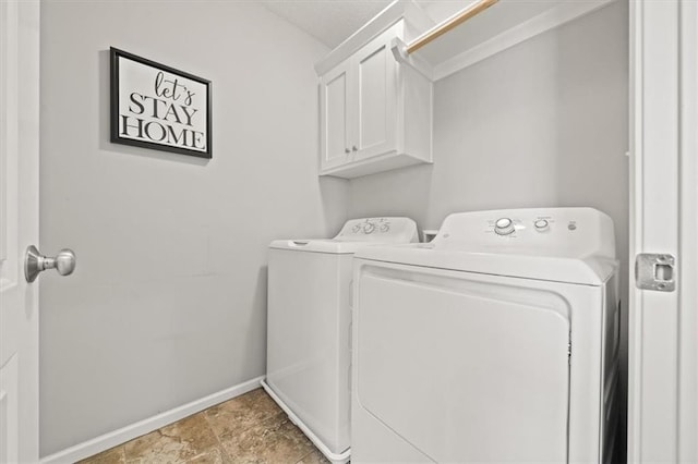 washroom with washing machine and dryer, cabinet space, and baseboards