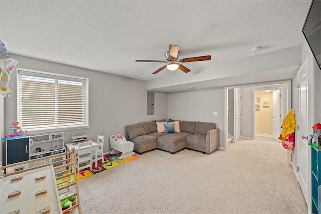 playroom featuring light carpet, ceiling fan, a textured ceiling, and electric panel