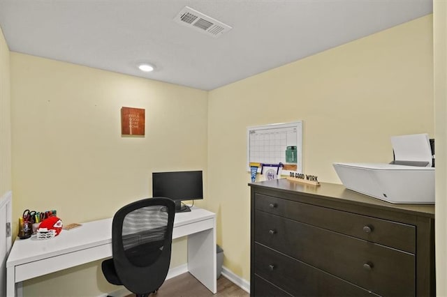 home office with visible vents, baseboards, and wood finished floors