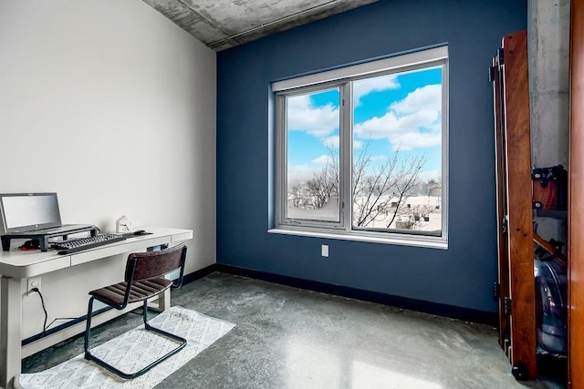 office featuring concrete floors, baseboards, and a wealth of natural light