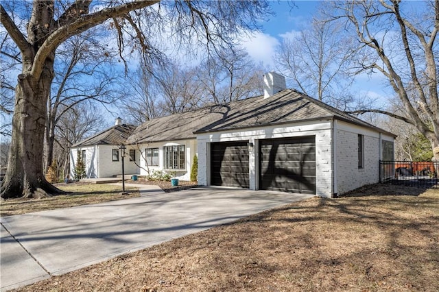 ranch-style home featuring an attached garage, brick siding, driveway, and a chimney