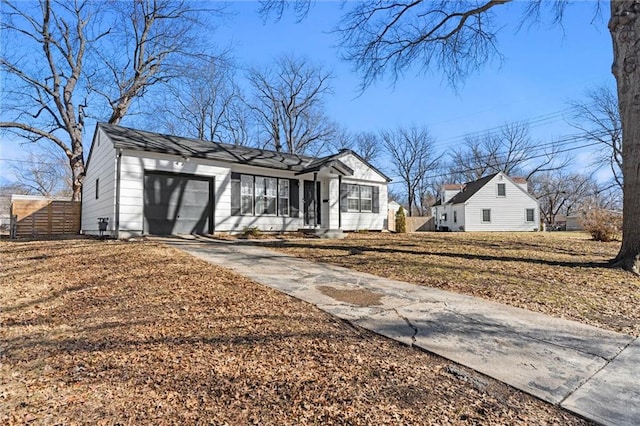 view of front facade with driveway, an attached garage, and fence