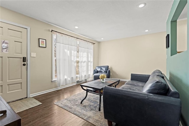 living room with baseboards, wood finished floors, and recessed lighting