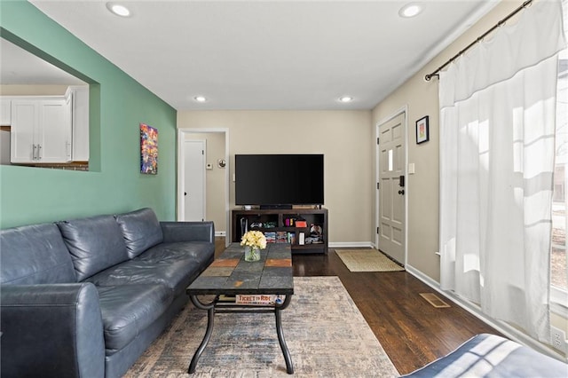 living area with recessed lighting, dark wood-style flooring, and baseboards