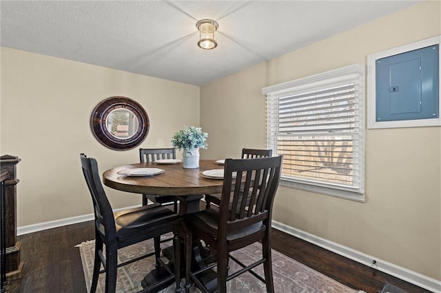 dining space featuring electric panel, baseboards, dark wood finished floors, and a textured ceiling