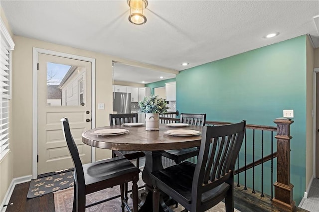 dining space featuring recessed lighting, a textured ceiling, baseboards, and wood finished floors